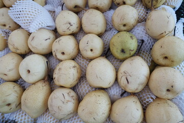 Pile of yellow pears for sale in a market.