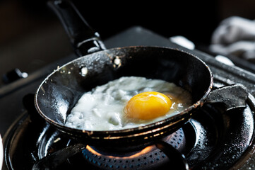 Closeup of cooking an egg in a frying pan