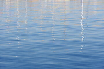 ヨットのマストが映る穏やかな水面