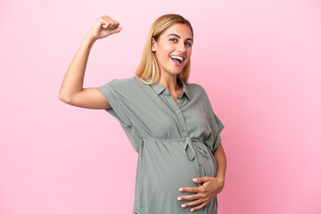 Young Uruguayan woman isolated on blue background pregnant and doing strong gesture