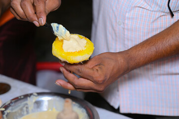 A picture of hands of a hawker holding ice gola (ice candy)