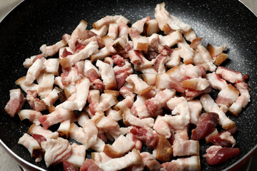 Cooking cracklings in frying pan, closeup. Pork lard