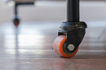 Close-up of heavy duty caster wheel on the floor. Mobile furniture on small wheels. Rack wheel for move equipment.