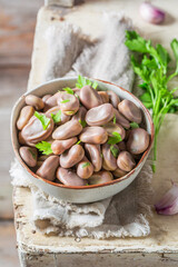 Hot boiled broad beans with garlic and parsley.