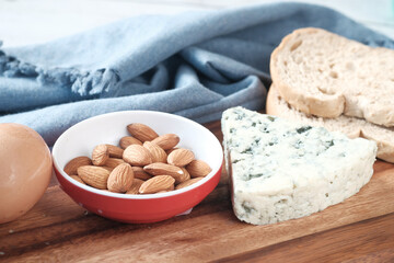 cheese, milk , brown bread and almond nut on table.