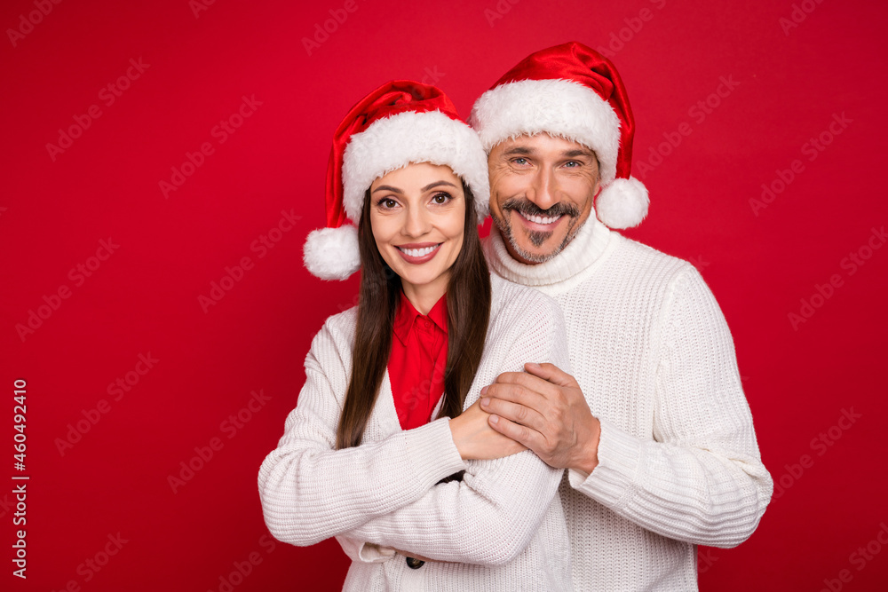 Poster photo of happy positive mature man and woman hug wear santa claus headwear enjoy holiday isolated on