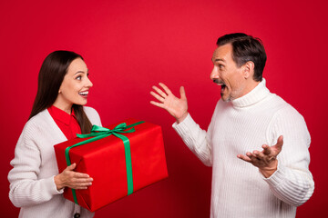 Photo of stylish trendy man and woman husband wife surprised gift give holiday isolated on red color background