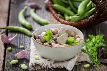 Tasty broad beans boiled with garlic. Healthy country snack.