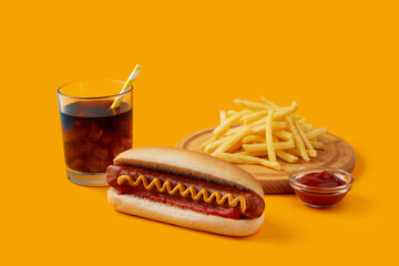 Hot dog with french fries and soft drink on orange background. Restaurant cafe menu