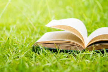 Open book on green grass. Shallow depth of field.