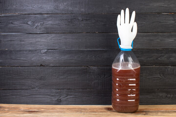 The production of wine. A plastic bottle with a young homemade wine and put on the neck of a rubber...