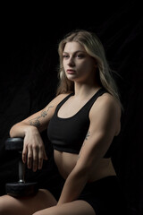 Fototapeta na wymiar Portrait of a blonde beautiful sportswoman in the fitness room.