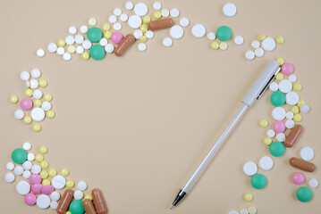 Free space among pills and a pen for writing on a beige background