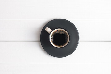 Top view black coffee with some foam isolated on a white wooden table