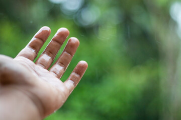 Rainy wet hands and a green bokeh background.Rainy wet hands and a green bokeh background.