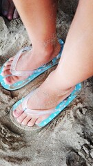 piedi di bimba in infradito sulla sabbia