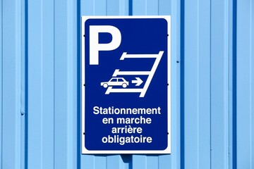 Fototapeta premium Reverse parking only sign on a wall called stationnement en marche arriere obligatoire in french language 
