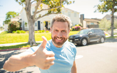 Naklejka premium emotional mature guy gesturing. happy man outdoor on new house background.