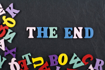 THE END word on black board background composed from colorful abc alphabet block wooden letters, copy space for ad text. Learning english concept.