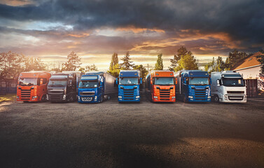 Trucks parked at sunset dramatic landscape, transportation, logistics concept image