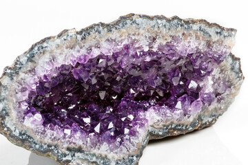Macro Mineral Stone Amethysts in the rock on a white background