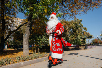 Santa Claus is in a hurry on a scooter with gifts for the holiday to the children.