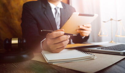 Business and lawyers discussing contract papers with brass scale on desk in office. Law, legal services, advice, justice and law concept picture with film grain effect