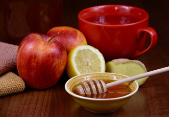 Autumn still life with honey, apples, ginger and a cup of tea stock images. Bowl of honey with a dipper, lemon, red apples and ginger on the table stock photo. Healthy food when sick images
