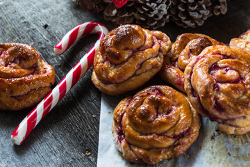 Swedish Christmas traditions. Saffron raisin buns on wooden background with Christmas decorations, selective focus. Christmas mood. New Year dish