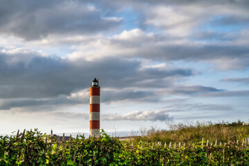 lighthouse of Berck sur mer in front of a cloudy but colorful sky.