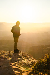 man hiking at sunrise in canyonlands national park in the summer in moab uath