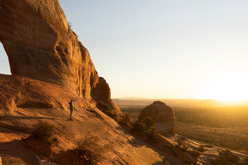 man hikig in arches national park at sunrise in moab utah