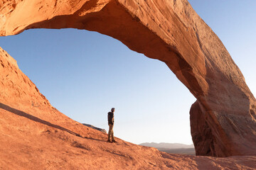 man hikig in arches national park at sunrise in moab utah