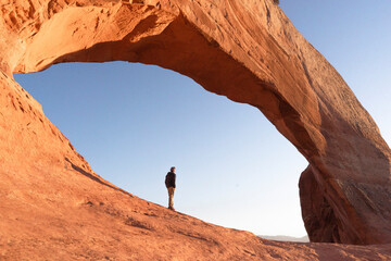 man hikig in arches national park at sunrise in moab utah
