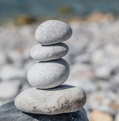 Fototapeta na wymiar Zen balance stones, smooth pebbles pyramid stacked on blue background.