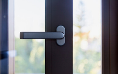 Aluminum door window close up, open glass frame with black handle, blur background