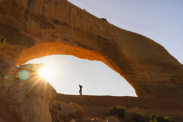 hiker arches national park during sunrise