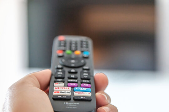 TV remote control in male hand, Watching television and channel switching.