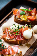 Bruschetta with prosciutto and pesto sauce on plate. Bruschetta with hamon, melon and honey. Spanish appetizer. Italian antipasti. Christmas food.