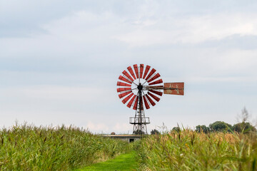 nostalgisches großes rundes rotes Windrad in der Landschaft