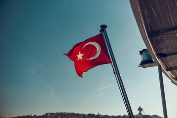 Turkish flag waving in blue sky.
