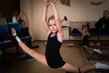 Girl gymnast stretching on training in sports camp