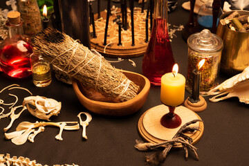 Witchy table arranged with witch craft magic items. Selective focus at front. Still life with black...