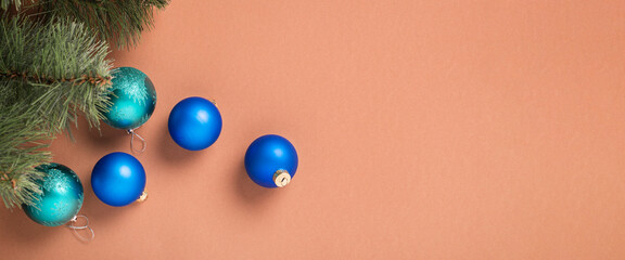 Fir branches and Christmas tree decorations on a brown background. Concept for New Years and Christmas Eve. Banner