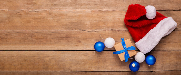 Santa's hat on a wooden background. Concept for Christmas, New Year. Top view, flat lay. Banner