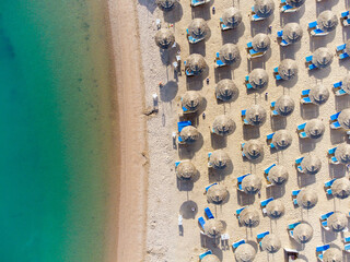 Top down view of a beach with tourists suntbeds and umbrellas with sand beach and clear blue water in egypt