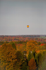 Hot air balloon flying over Wisconsin forest and farmland in late September
