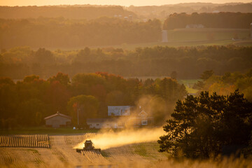 Fototapeta premium Dust kicking up from a farmers combine in a Wisconsin soybean field