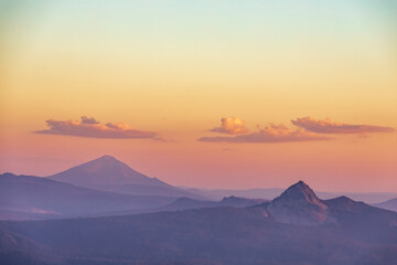 Naklejka premium dramatic sunset along the mountain range viewed from Watchman observation station in Crater lake National Park in Oregon.