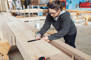 Female carpenter working with a right angle tool